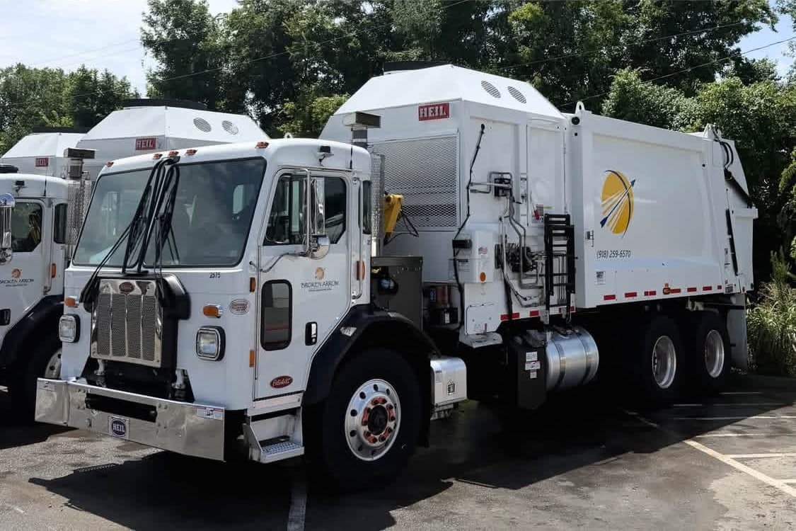 The same refuse packer truck after a fleet wash, with clean white bodywork, bright trim and polished wheels