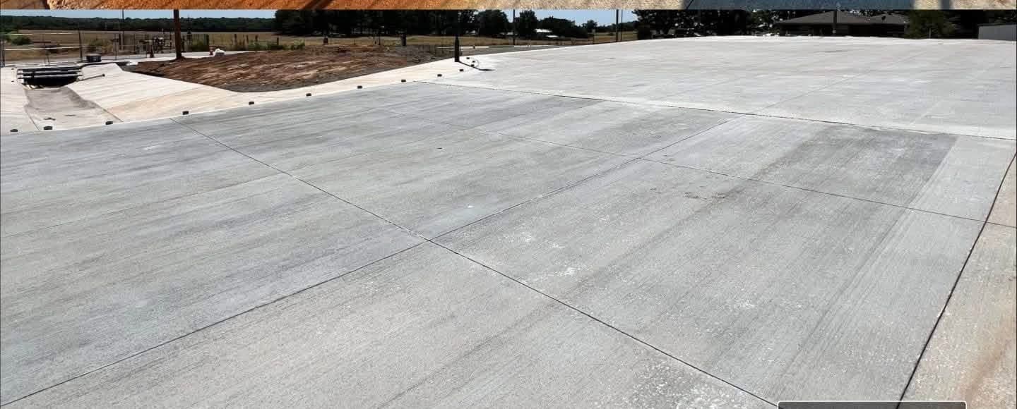 The same commercial concrete pad after rust removal, returned to an even grey finish