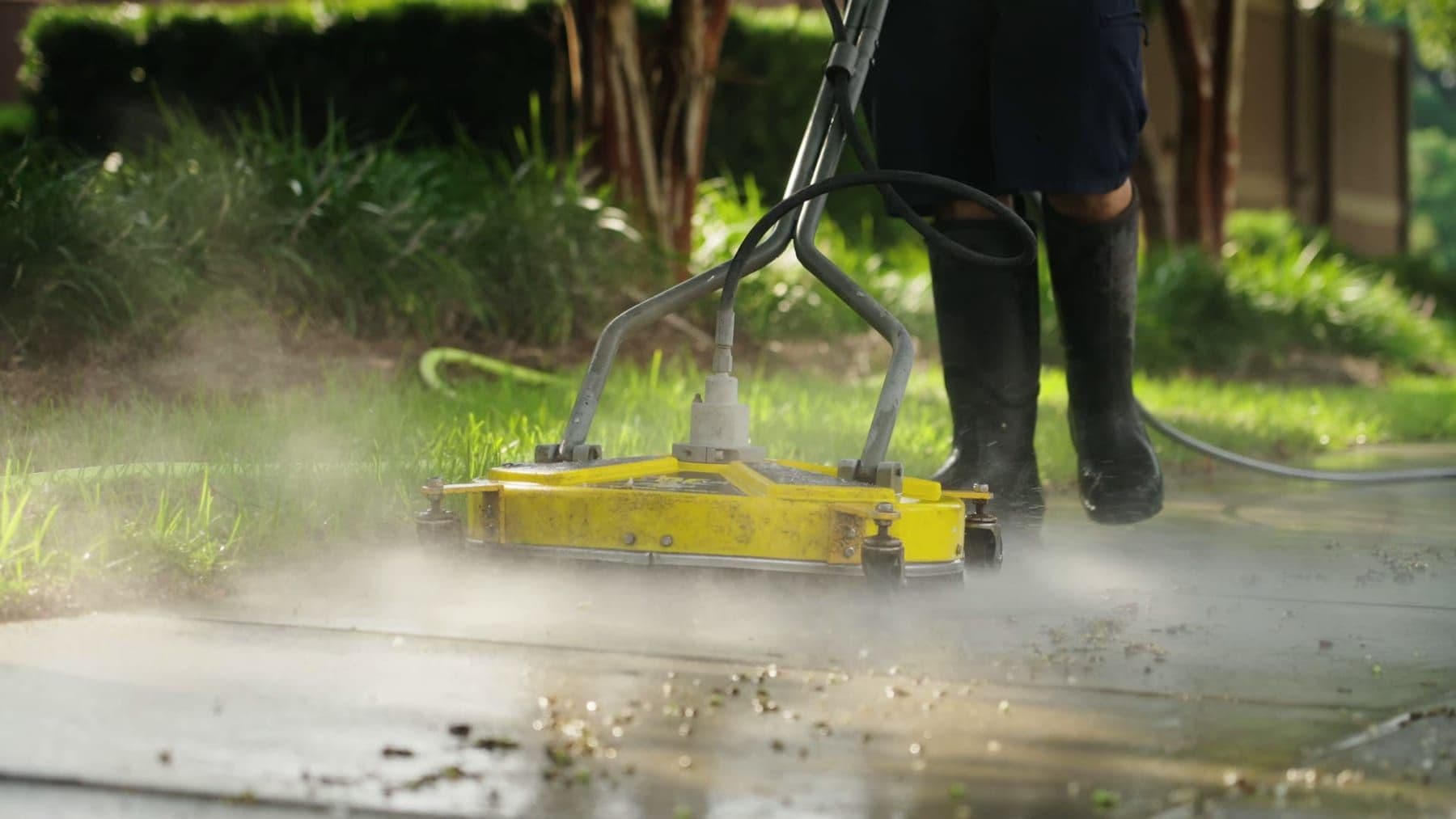 Surface cleaner attachment cutting a clean pass across concrete flatwork in Charleston, SC