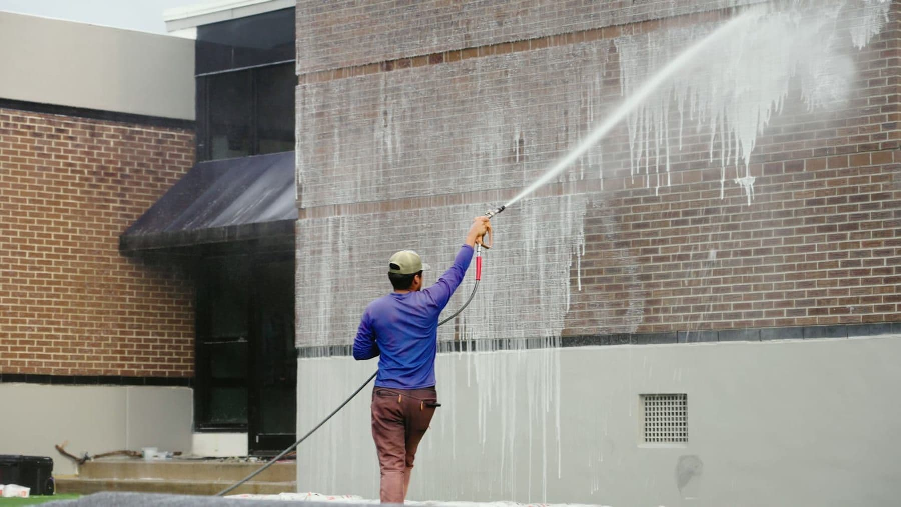 Commercial brick building being soft washed from the ground in Charleston, SC